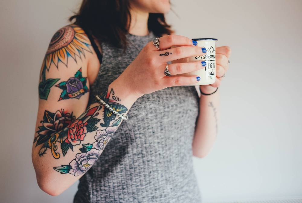 Woman with tattoos having a cup of tea